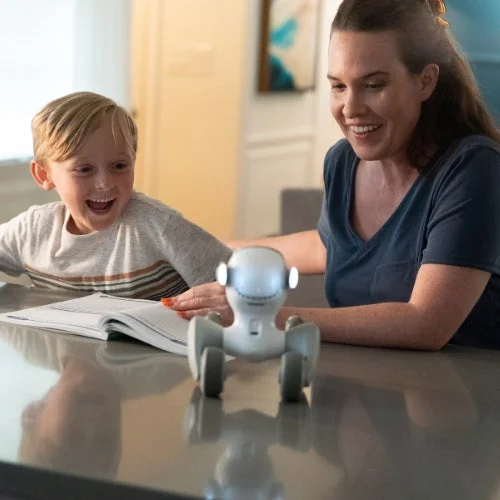 Loonaがテーブルの上で子どもと女性を楽しませる様子