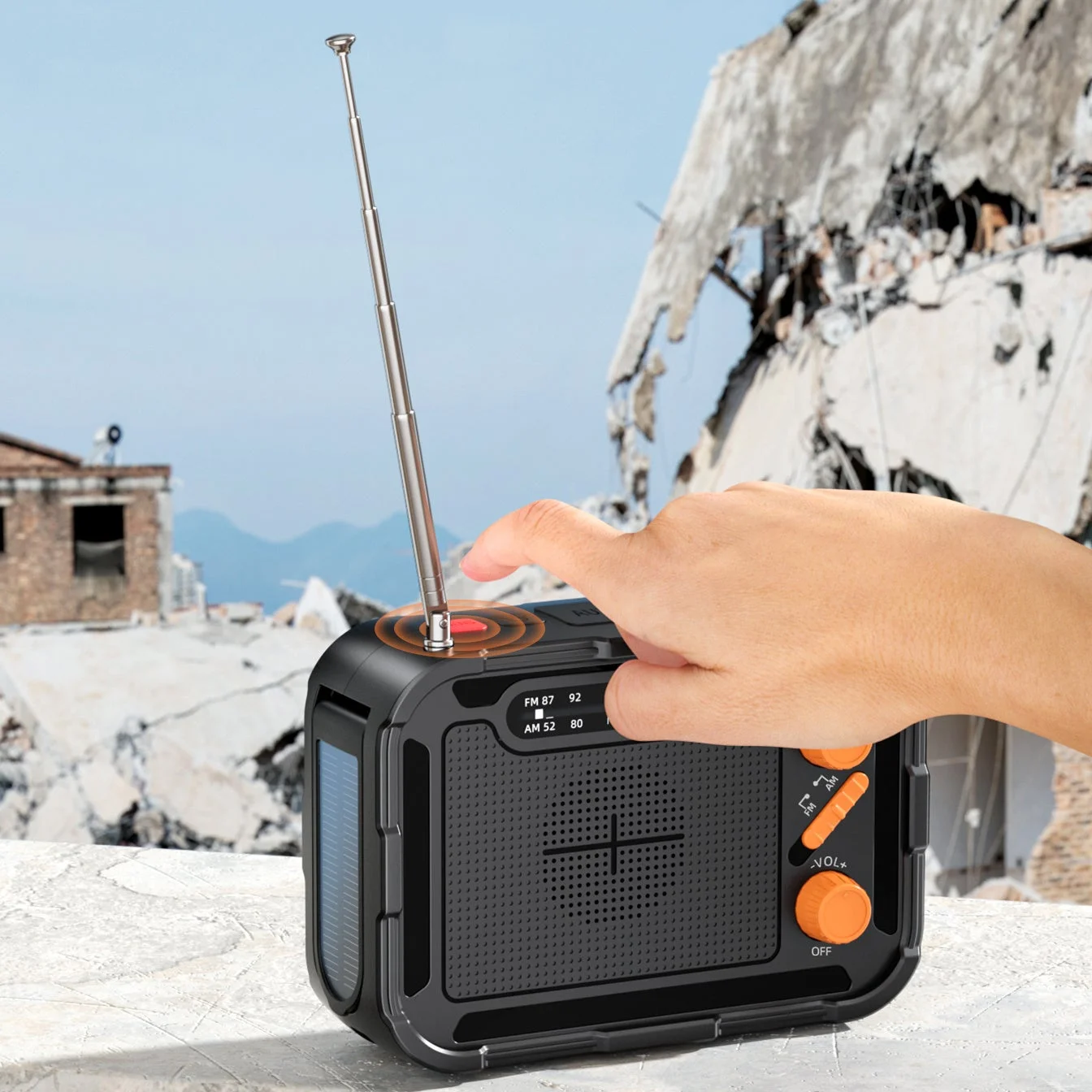 災害現場を想定した場所でSOSボタンを押す多機能ラジオ