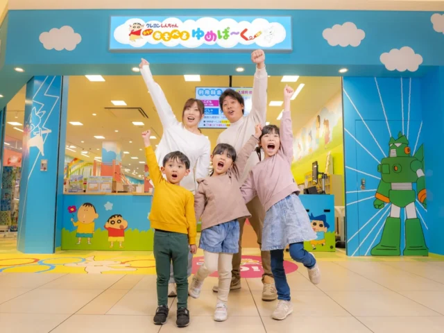 「クレヨンしんちゃん オラの あそべるゆめぱ～く」入口でポーズをとる家族