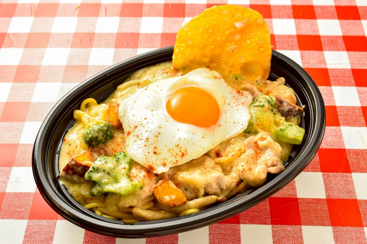 テイクアウト容器に入った「シュクメルリ風パスタ」目玉焼きトッピング