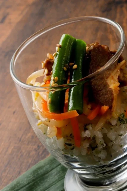 グラスに入った彩り豊かなビビンバ寿司パフェ