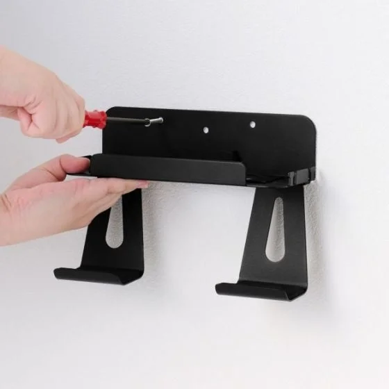 壁掛けスタンドを壁にネジで固定する様子