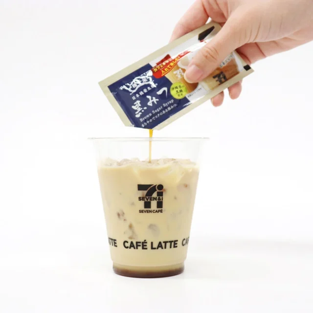 セブンカフェのアイスカフェラテに黒みつを入れる様子