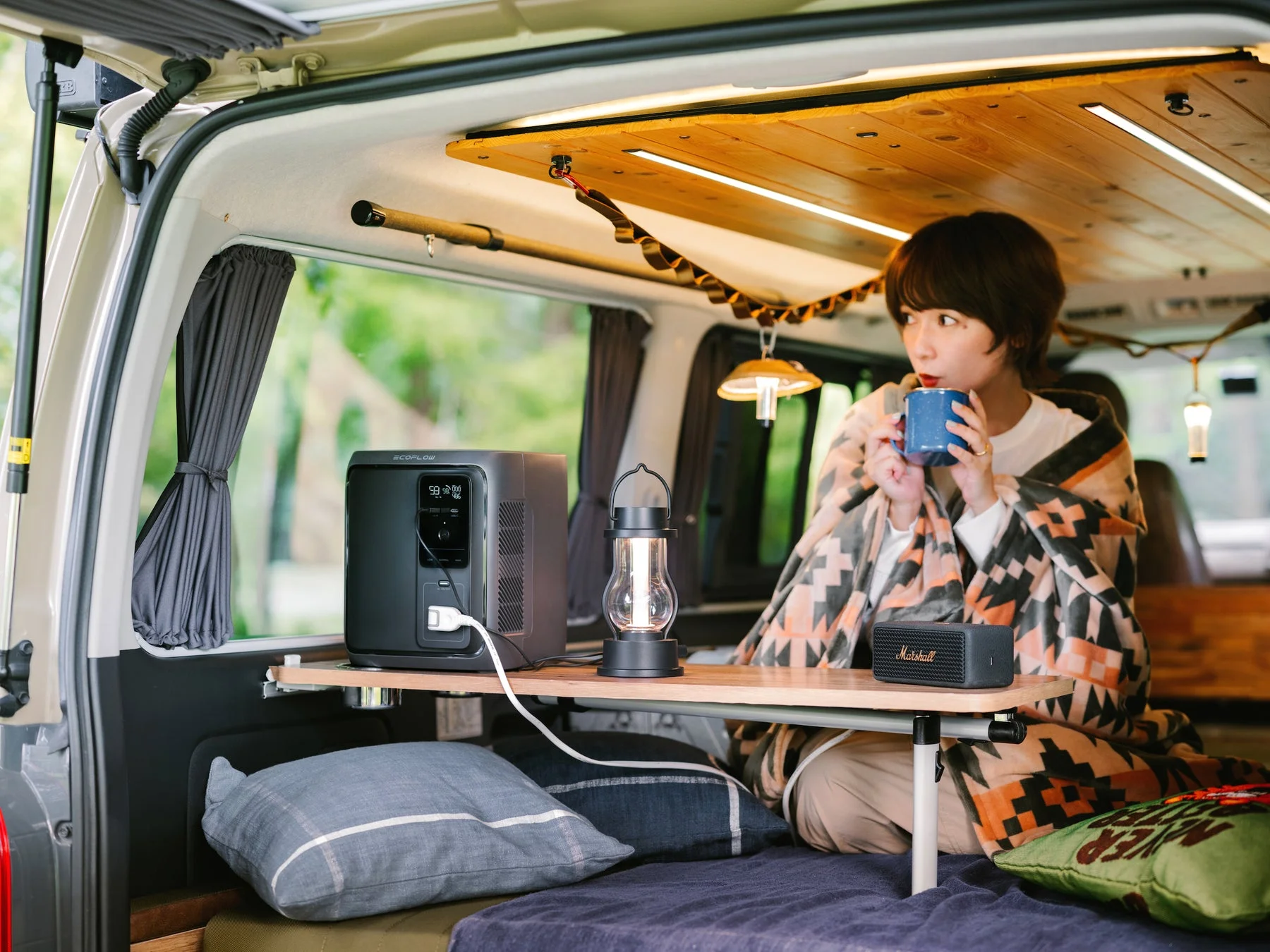 EcoFlowポータブル電源を車中泊で使う女性。快適なアウトドアシーン。