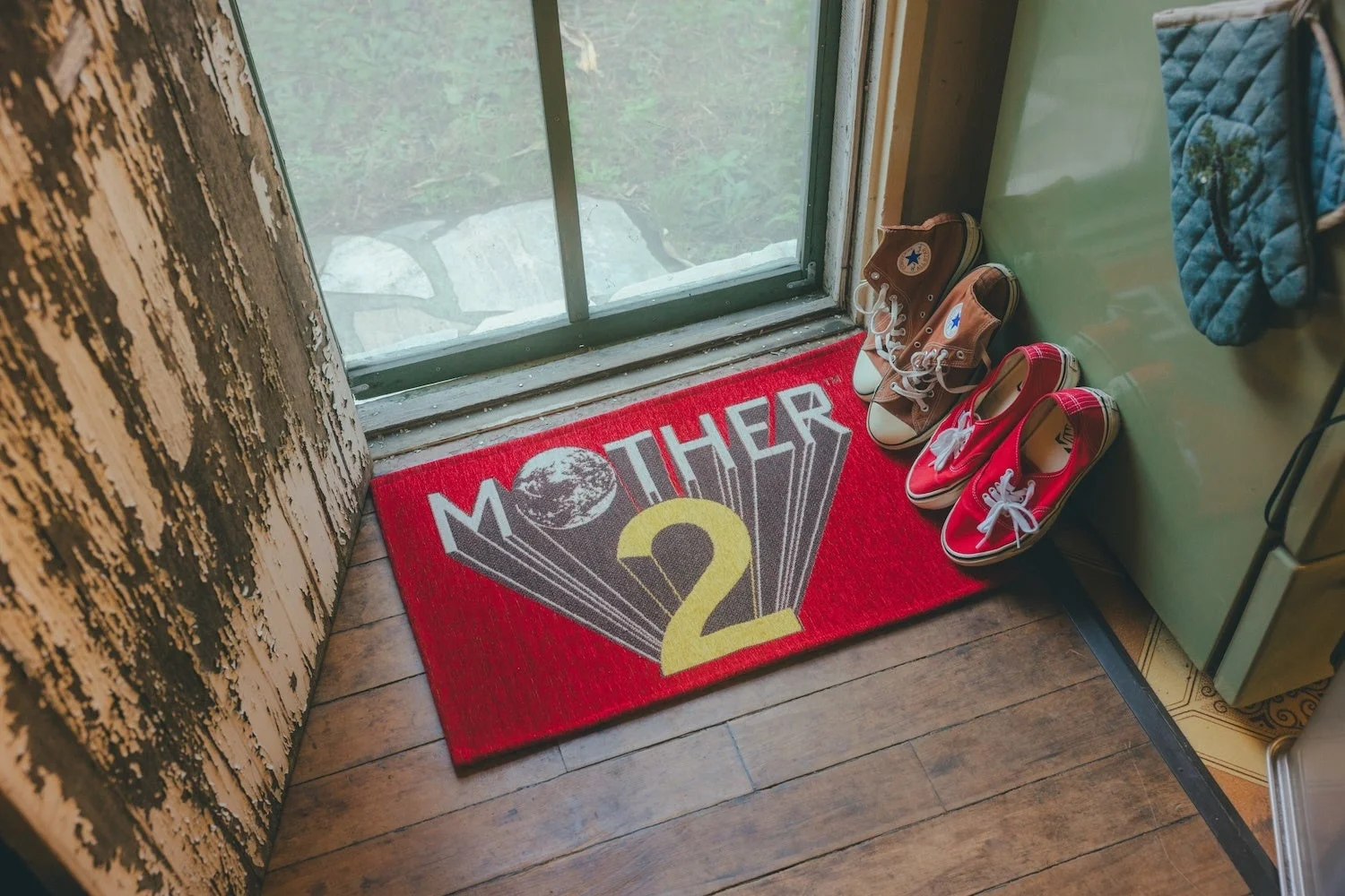 MOTHER2ロゴがデザインされた赤いラグマット