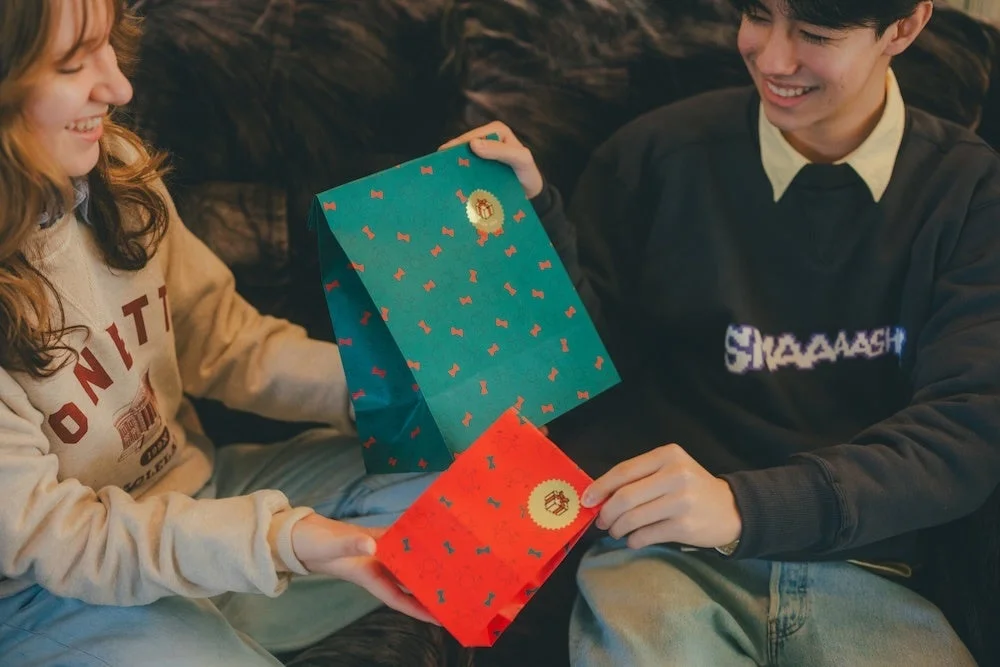どせいさん柄のペーパーギフトバッグを交換する二人