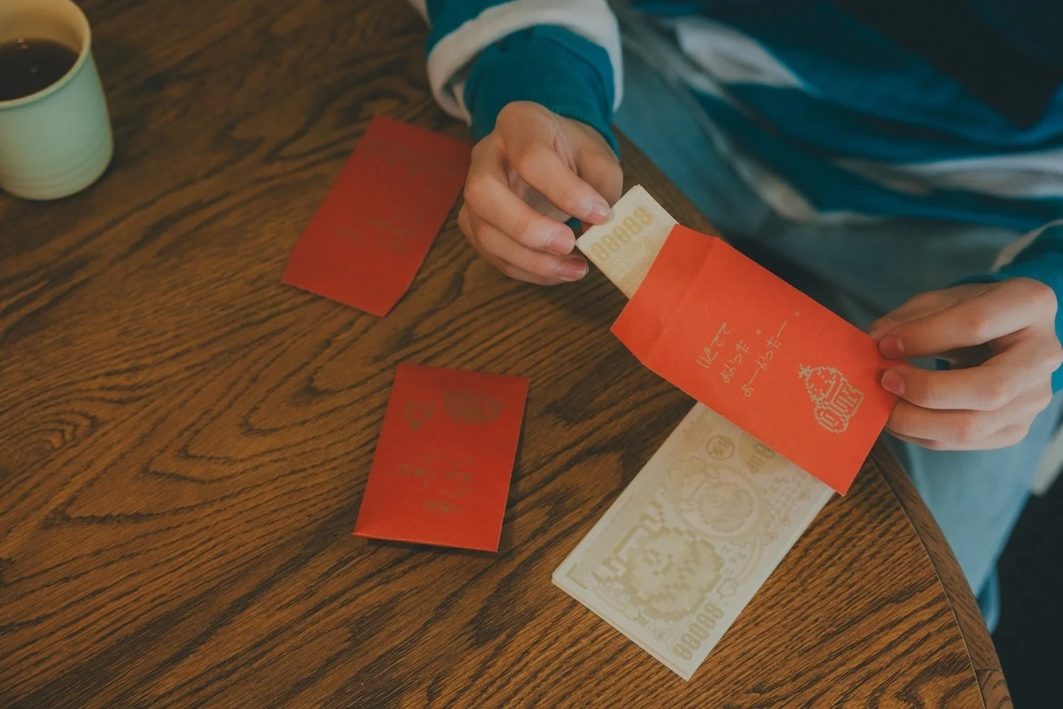 どせいさんデザインのポチ袋にお金を入れる手元