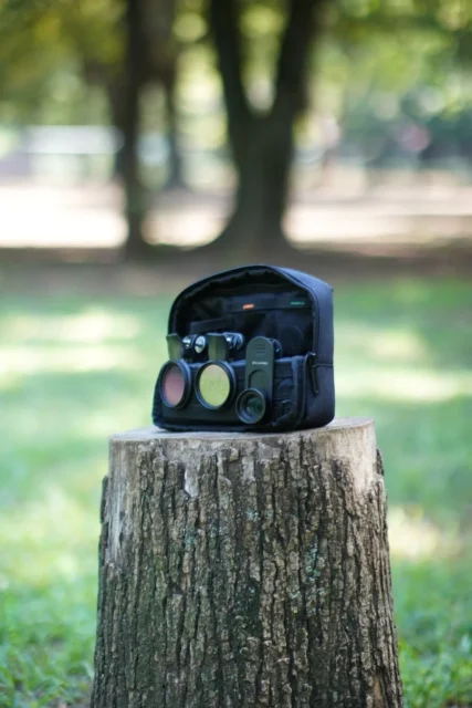 屋外の切り株に立てられたEXAPRO ガジェットポーチ グレー