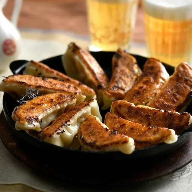 鉄板でこんがり焼かれたはちやの頑固餃子とビール