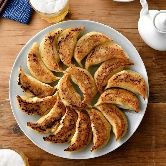 丸い皿に美しく盛り付けられた幸福飯店の魔法の焼き餃子