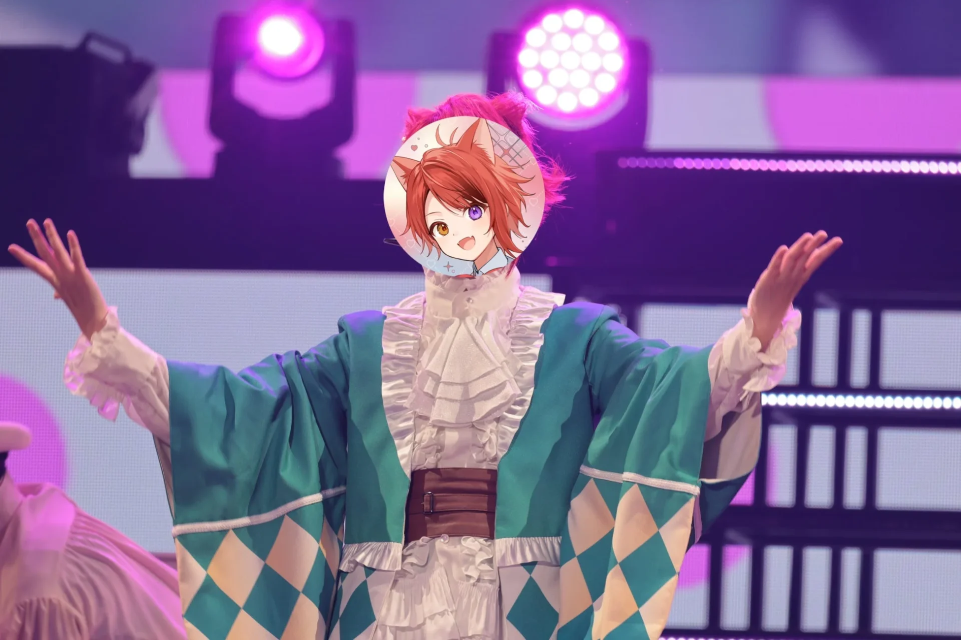 ライブで緑の衣装をまとい両手を広げる莉犬