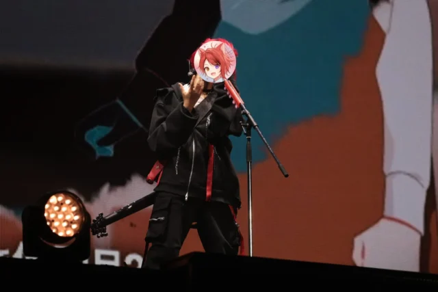 ライブで黒い衣装をまといマイクスタンドに向かう莉犬