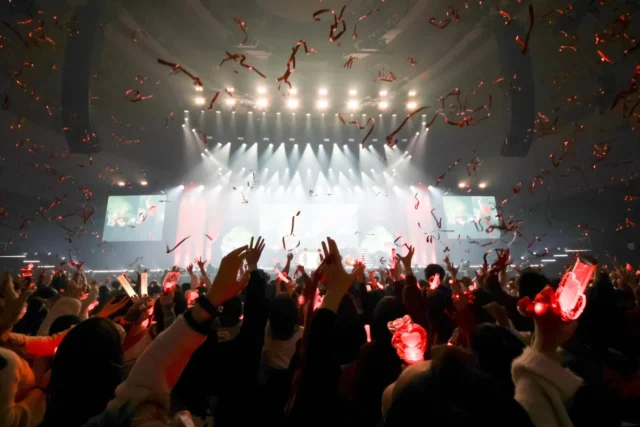 ライブ会場を埋め尽くす赤いペンライトと舞い上がる紙吹雪