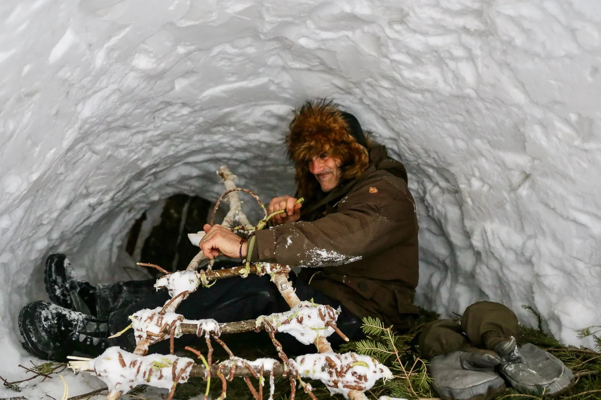 中国・長白山の雪洞で道具を加工するエド・スタフォード