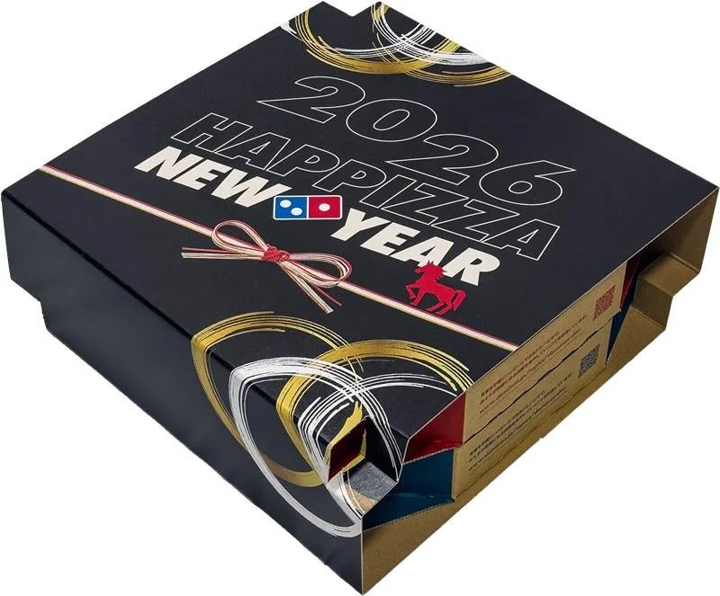 ドミノのお正月セットの「お重型ボックス」。黒地に「2026 HAPPY PIZZA NEW YEAR」と金色のお正月飾りがデザインされている。