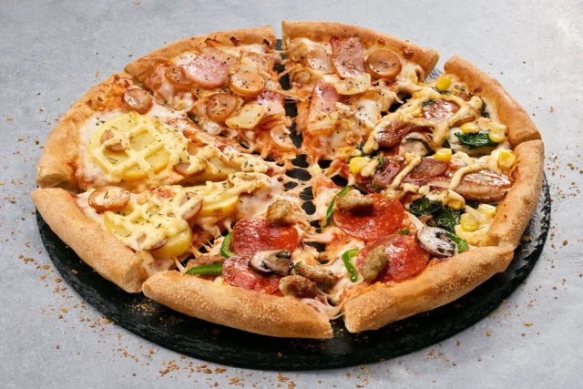 ドミノのおすすめピザ「クワトロ・ジャイアント」。4種類のトッピング（チキテリ、ドミノ・デラックス、マヨじゃが、ガーリック・マスター）が1枚に。