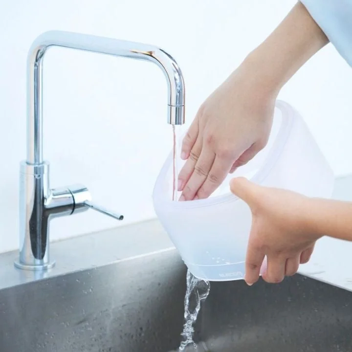 自動給餌器のフードタンクを水洗いする様子