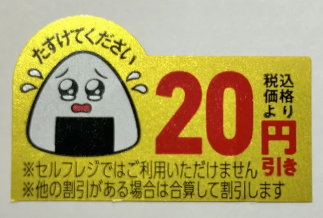 「たすけてください」と書かれたおにぎりキャラクターと「20円引き」の「涙目シール」