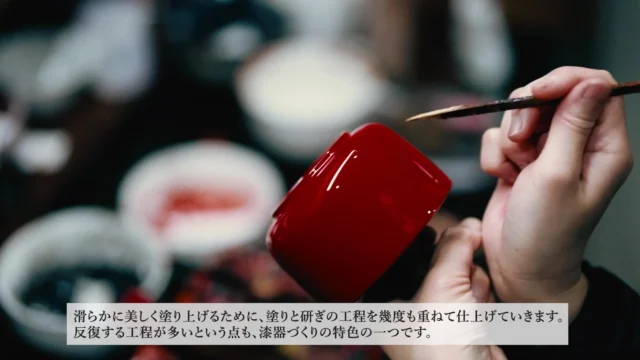 職人が漆器に漆を丁寧に塗る手作業の様子