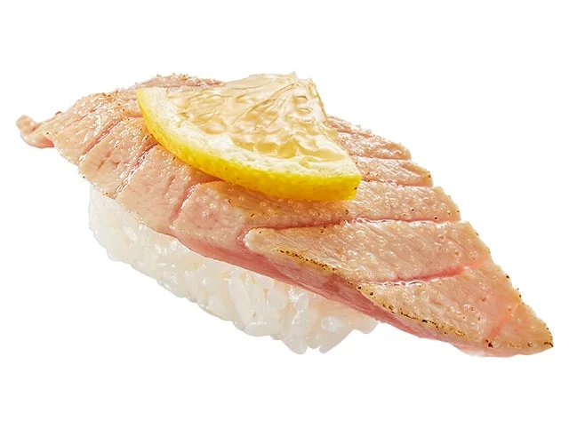 みなみ鮪の大とろを直火で炙り、レモンが添えられた一貫。