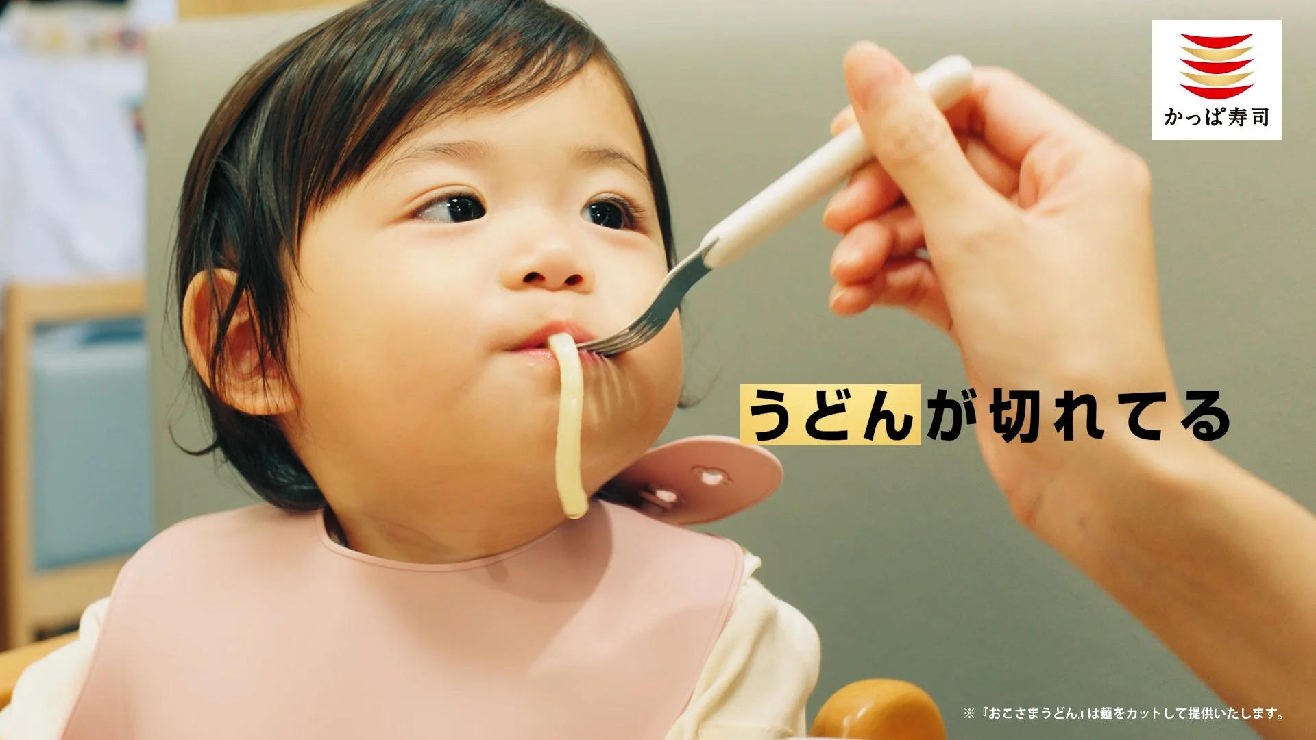 子供が短く切られたうどんをフォークで食べるCMのワンシーン。「うどんが切れてる」の文字が表示されている。