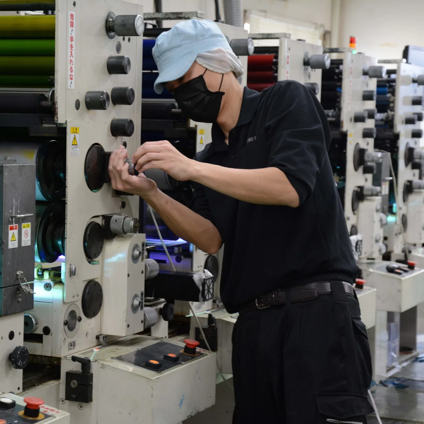 オフセット印刷機を調整する作業員