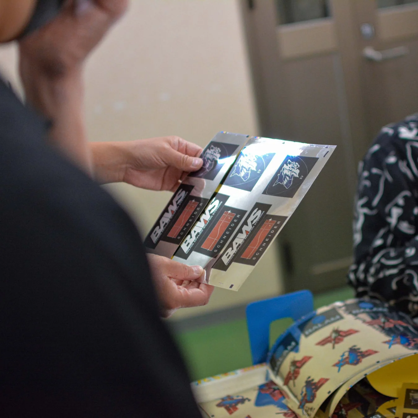 完成したメタルステッカーの仕上がりを確認する様子