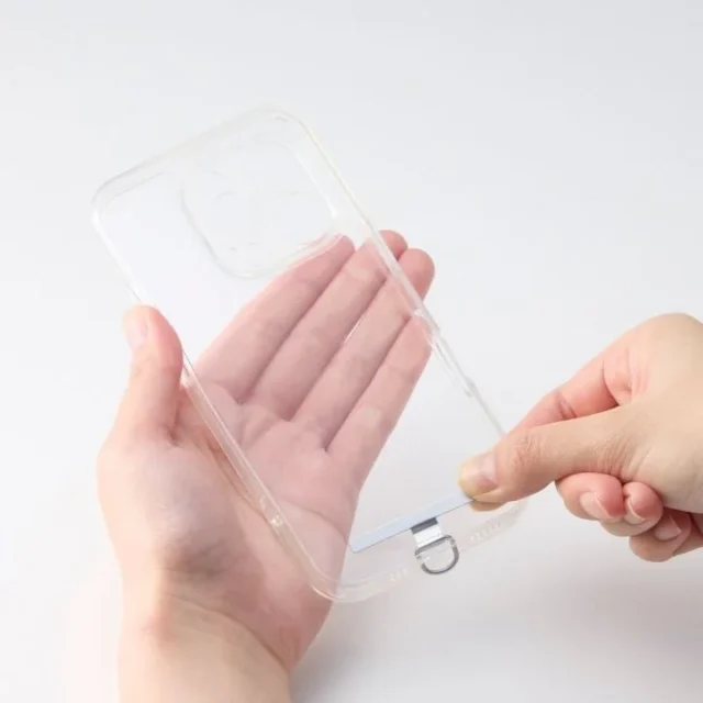 スマホケースのケーブル穴にシートを挟んで装着する様子