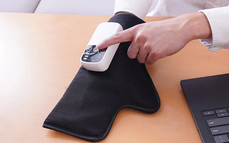 「スッキリハンドギア」の操作ボタンを押す手元