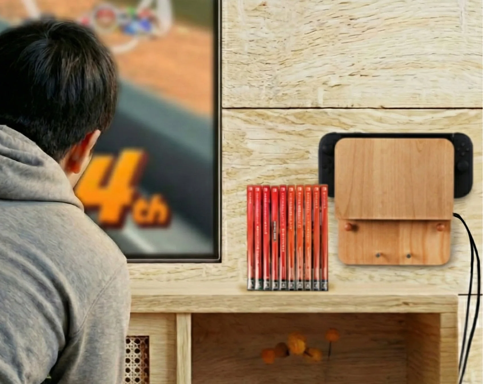 ゲームをプレイする人の横に、壁掛け収納されたNintendo Switch2とゲームソフト