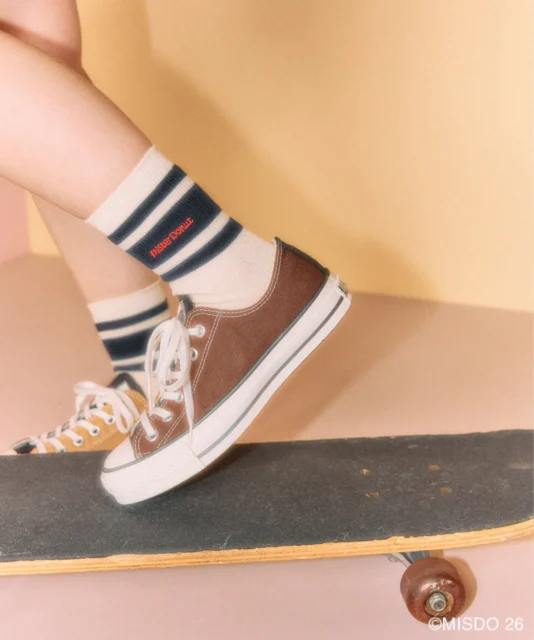 ミスタードーナツのロゴが刺繍されたラインソックスを着用した足元