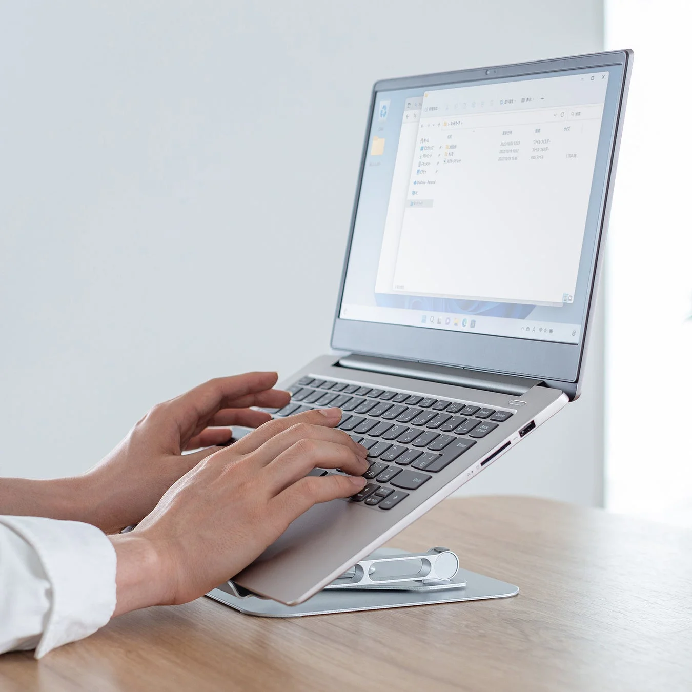 ノートパソコンスタンドに載せたPCでタイピングする様子