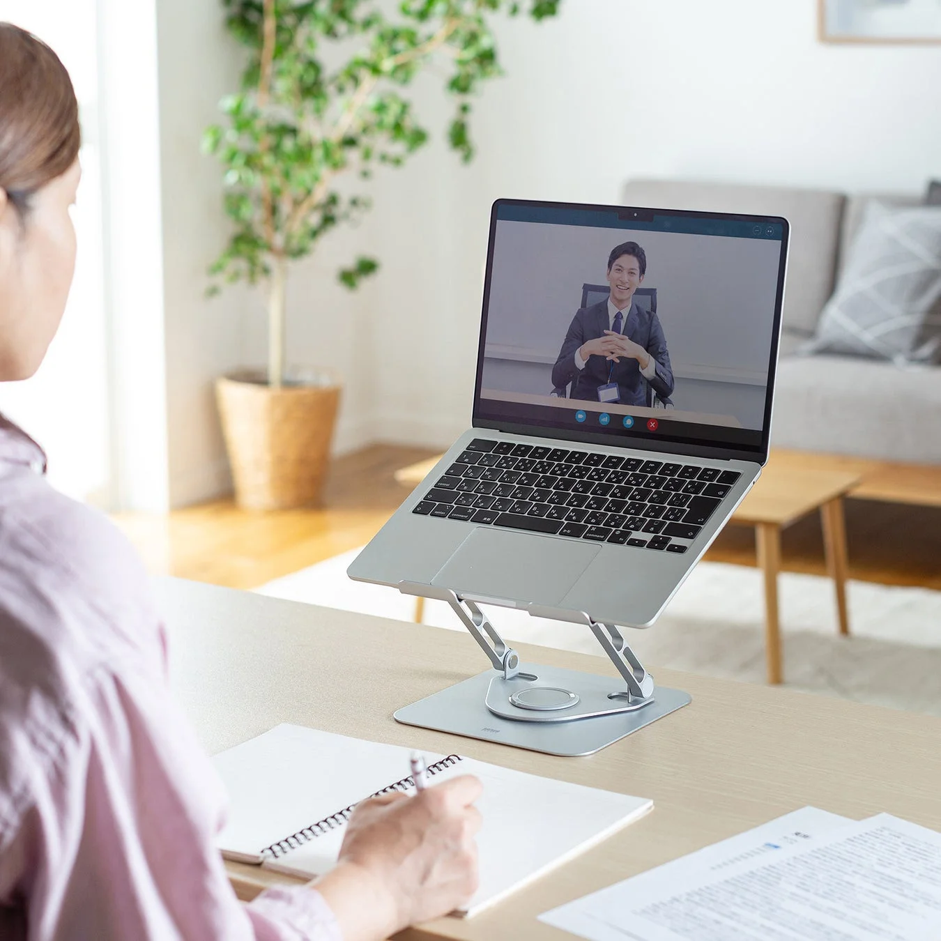 ノートパソコンスタンドに載せたPCでビデオ会議を行う様子