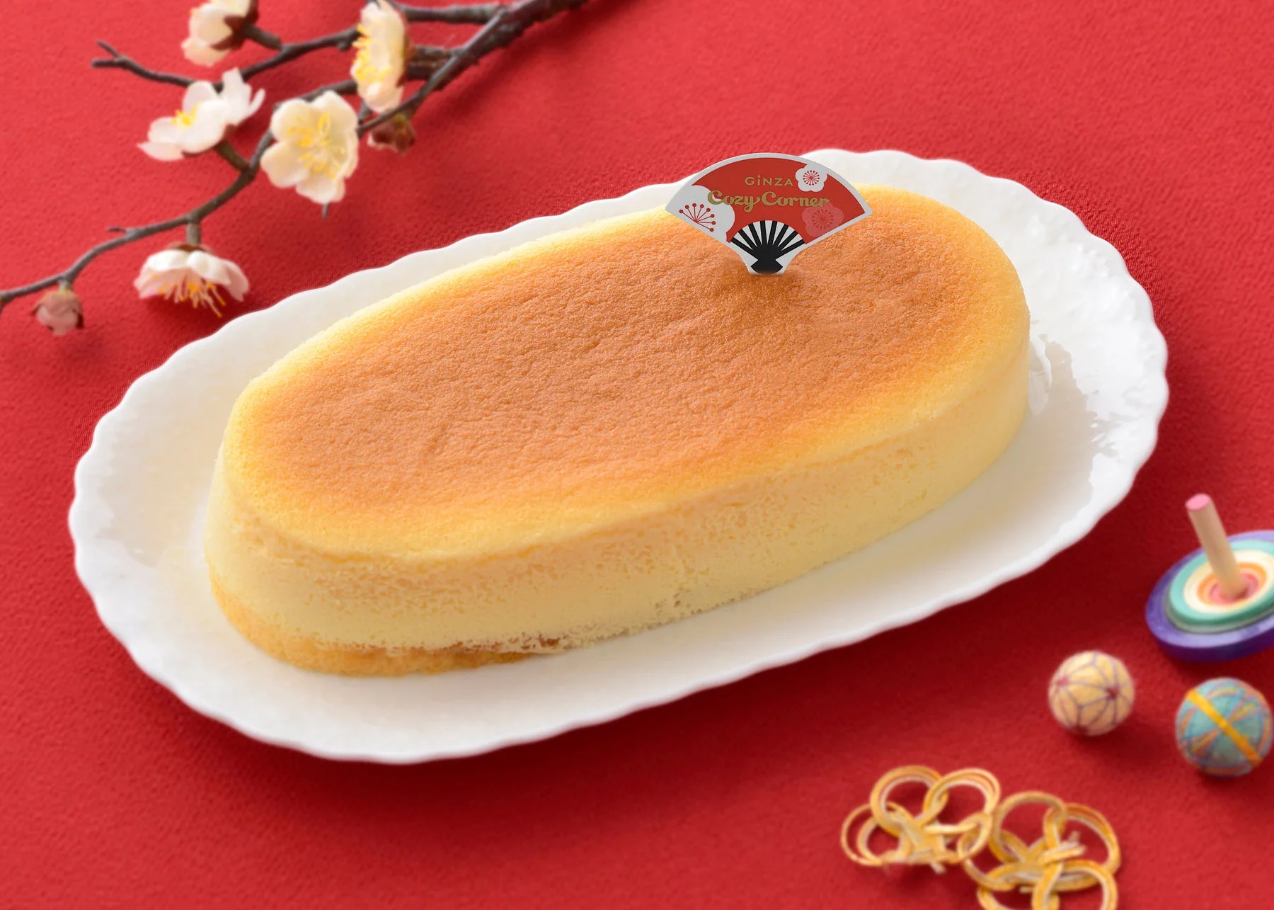 梅の花とコマが添えられた新春チーズスフレ