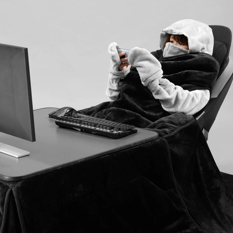 黒いゲーミング着る毛布を着用し、こたつでゲームする様子