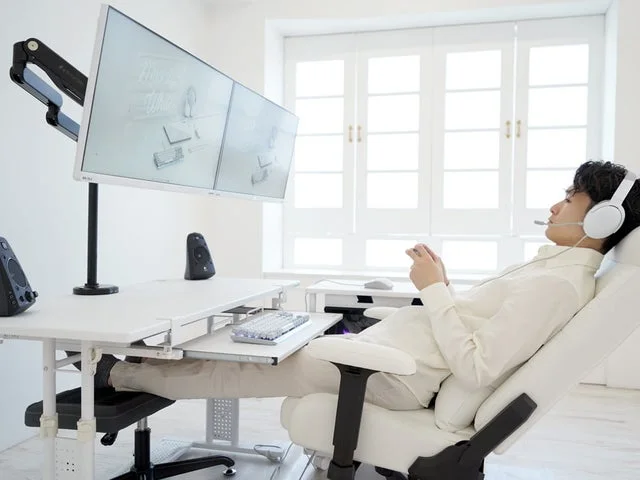 白いゲーミングデスクでリラックスしてゲームを楽しむ様子