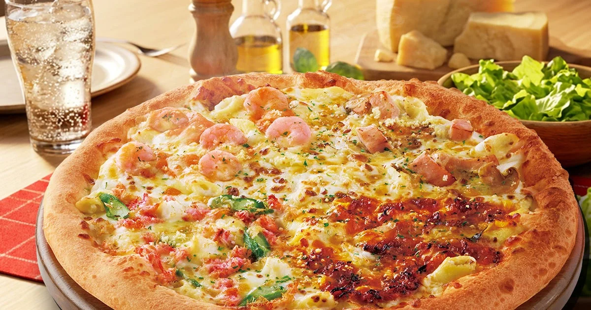 4種類のグラタンピザが1枚になった「ぎゅっとよくばりグラタン4」。海老、カニ、チキン、プルコギの具材が鮮やかに並ぶ。