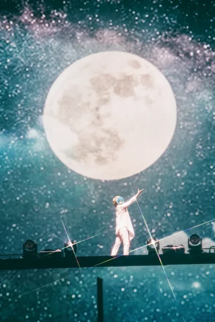月のプロジェクションを背景に「月は綺麗なのに」を歌唱するころん。