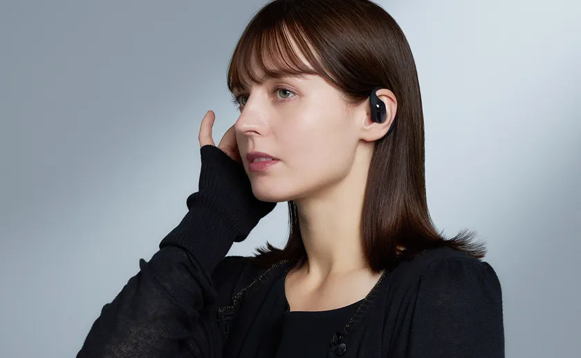 ブラックのHP-H300BTを装着し通話する女性の様子