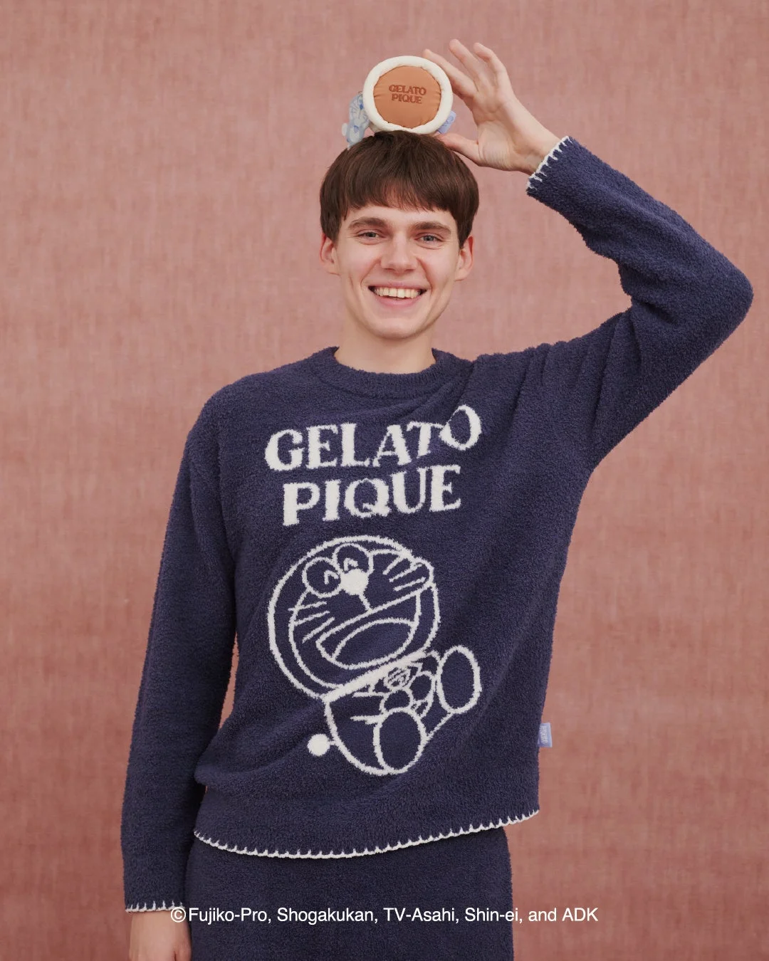 楽の表情のドラえもんニットプルオーバーを着た男性