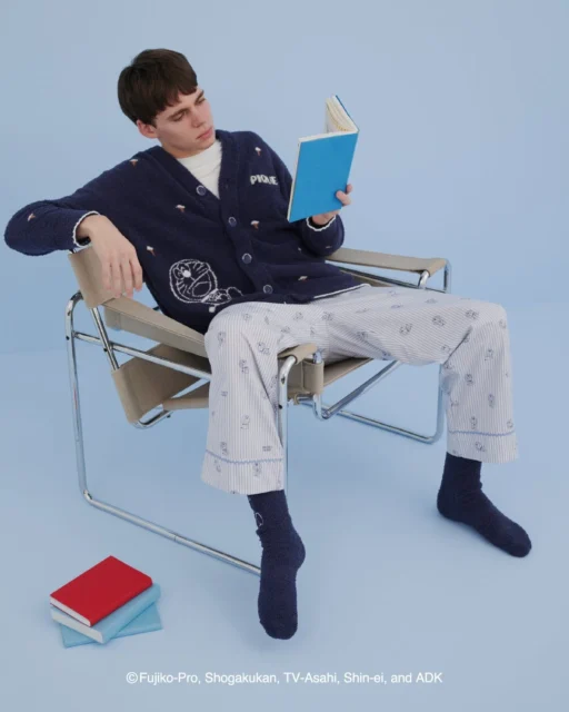 ドラえもんのメンズカーディガンを着て本を読む男性