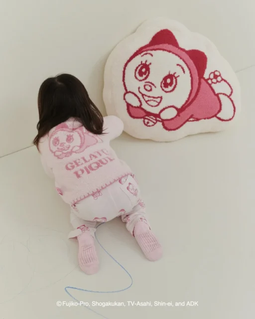 ドラミのベビーカーディガンを着た子供とクッション