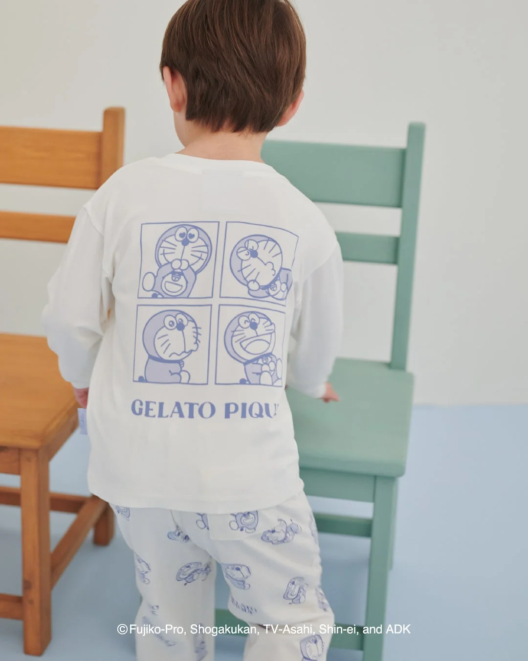 ドラえもんのプリントロンTと総柄ロングパンツを着た子供の後ろ姿