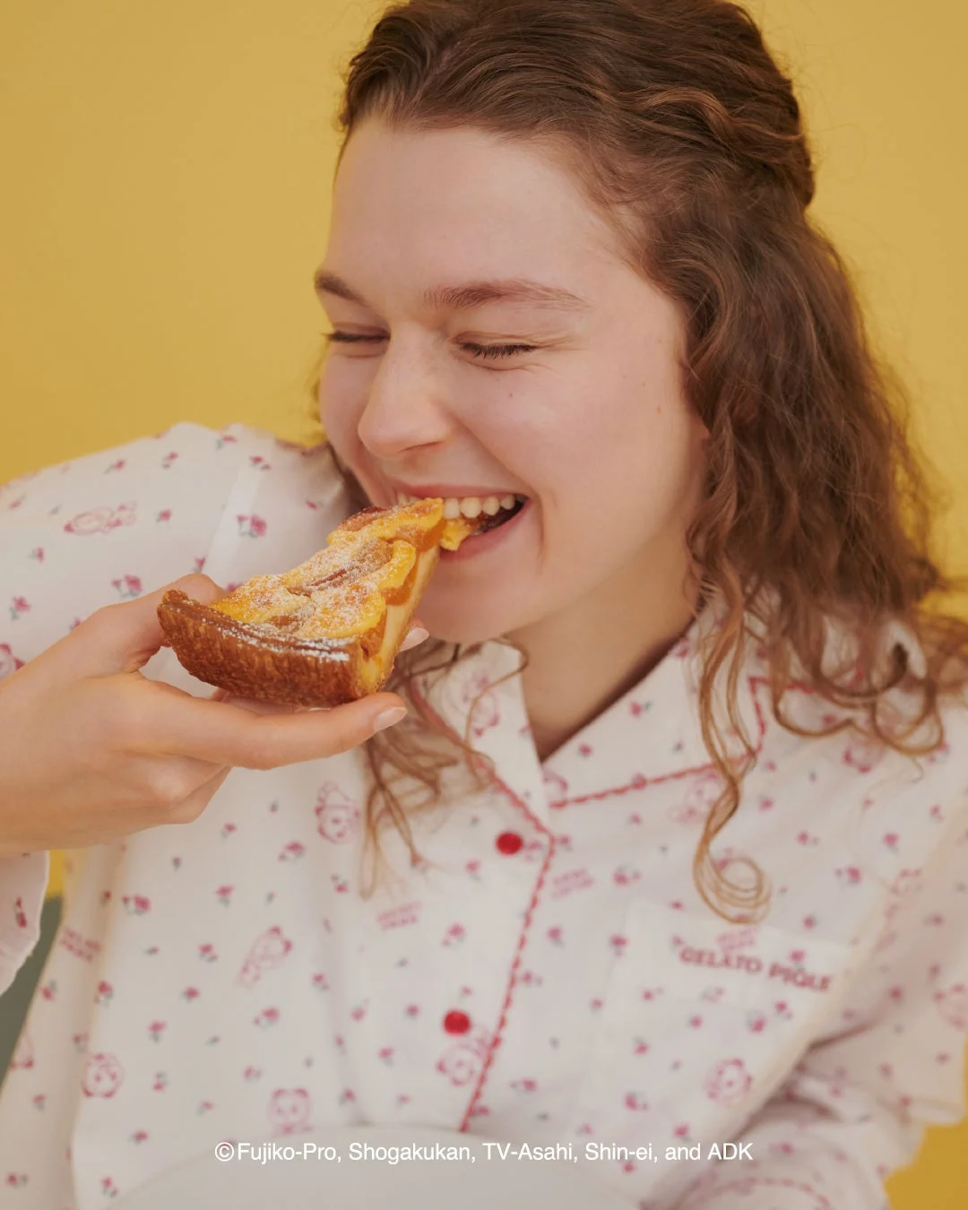 ドラミの小花柄シャツを着てパイを食べる女性のアップ