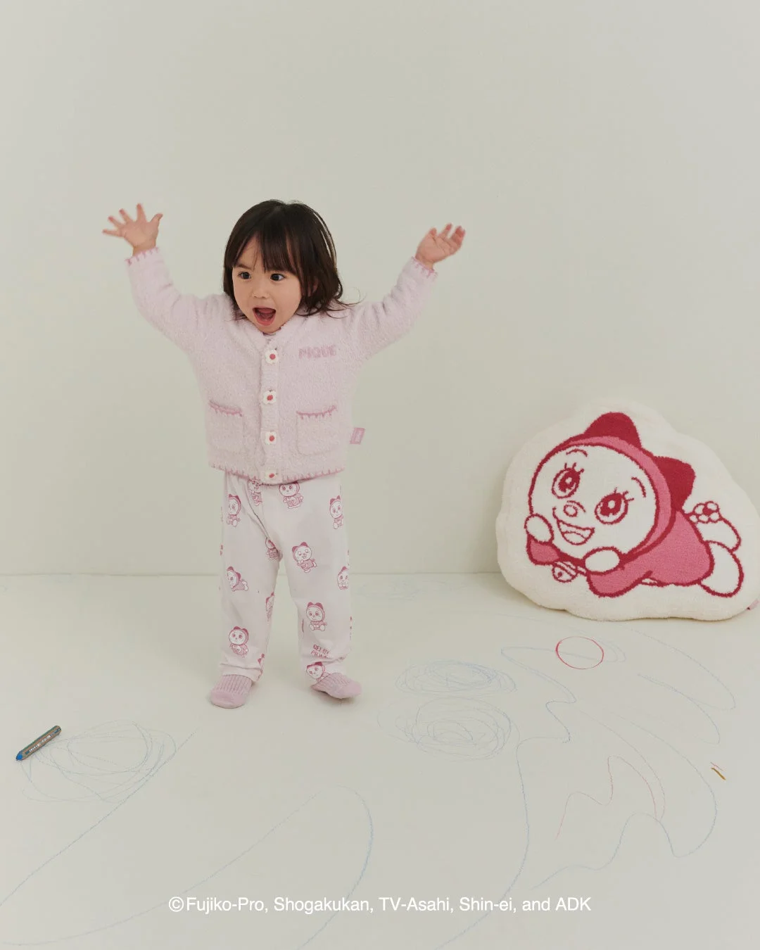 ドラミのベビモコジャガードクッションと寝具で遊ぶ子供