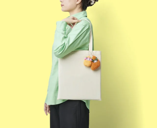 モスバーガーのマイメロディとクロミのマスコットをトートバッグに付けた使用イメージ