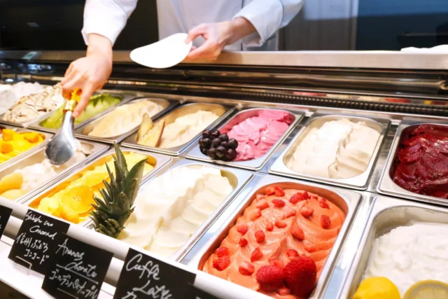 店内で手作りされた色とりどりの自家製ジェラートを盛り付ける様子