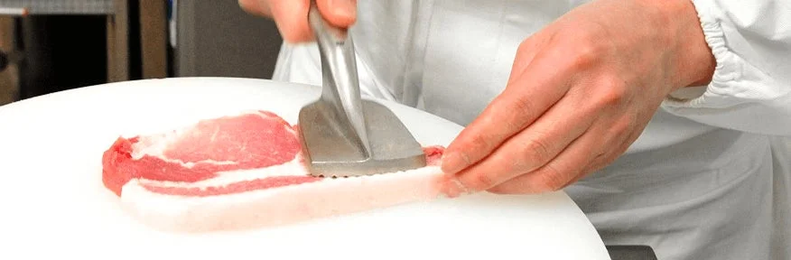 まい泉のとんかつに使用する豚肉を丁寧に下処理する様子