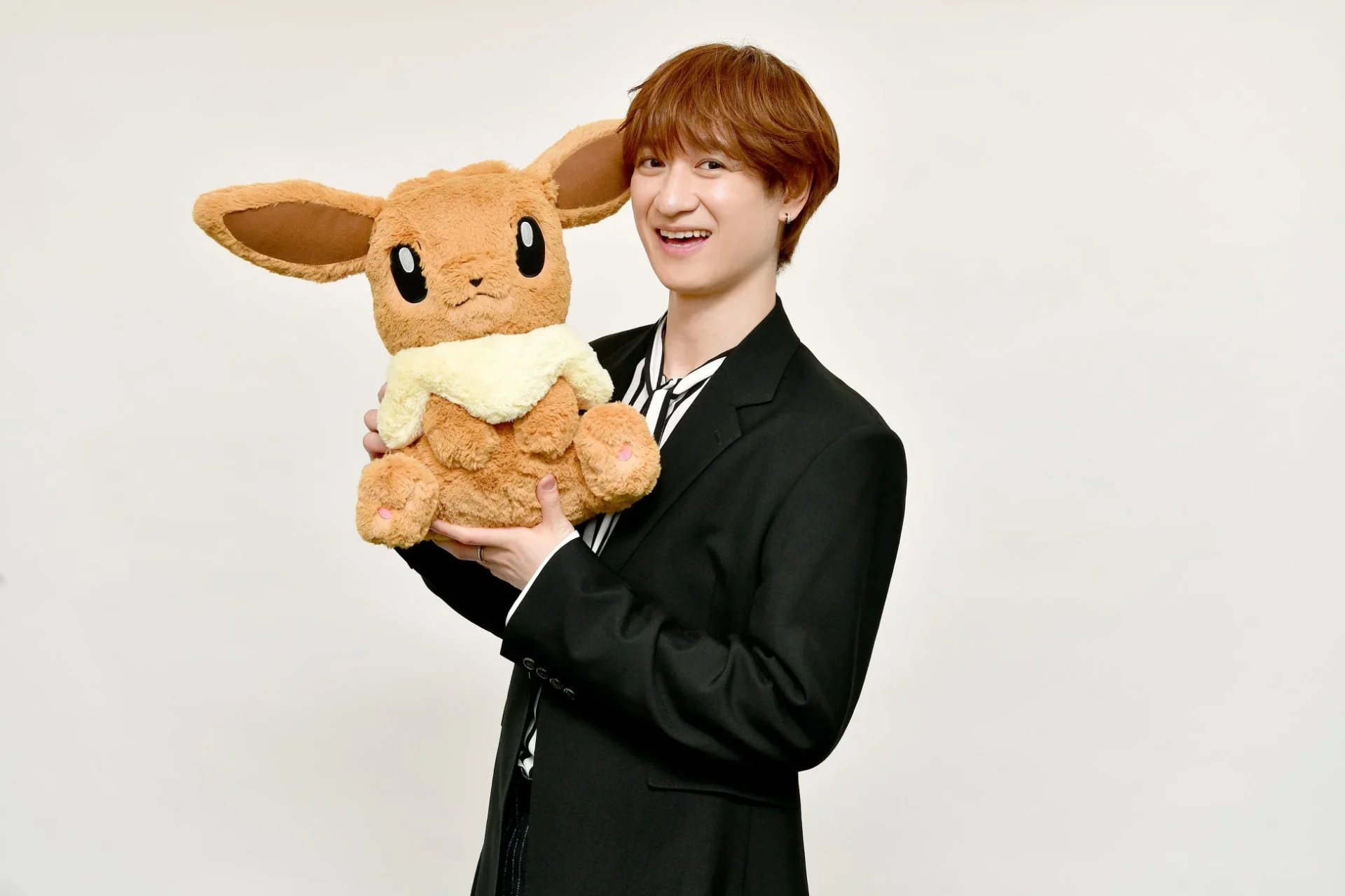 イーブイのぬいぐるみを持つ宮田俊哉さん