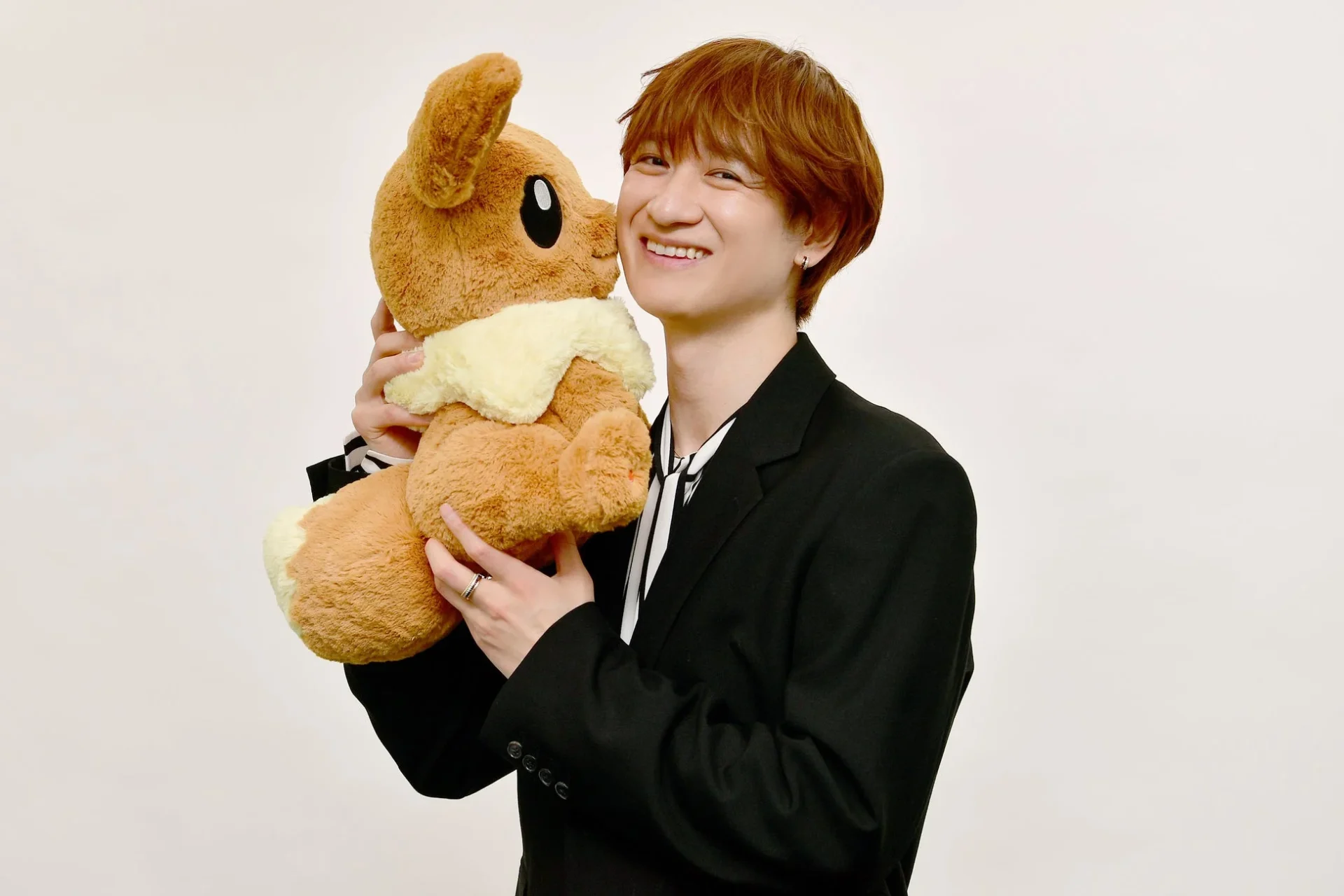 イーブイのぬいぐるみと笑顔の宮田俊哉さん